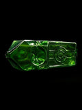 Green glass object with geometric design on a black background made by Kuhns Glass